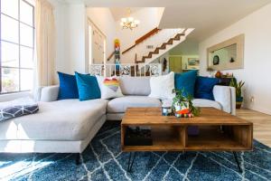 sala de estar con sofá blanco y almohadas azules en Spacious Family Retreat! Sleeps 12 + huge backyard, en San Juan Capistrano