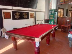 a red pool table sitting in a room at White Monkey in Siem Reap