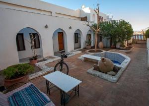 un patio con un edificio blanco con una mesa y un banco en Abouseif Guest House en Sharm El Sheikh