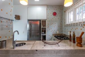 a kitchen with a sink and a refrigerator at Praia de Geriba - Fantastica Vista Mar in Búzios