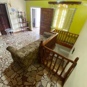 a living room with a staircase and a chair in a room at Cozy Family Inn in Port Antonio