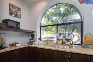 a kitchen with a counter with a window at Rodeway Inn Milpitas near Great Mall in Milpitas