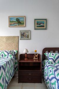 Un dormitorio con dos camas y una mesita de noche con lámpara. en Praia de Geriba - Fantastica Vista Mar, en Búzios