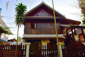 a house with a fence in front of it at Thatsaphone Hotel in Luang Prabang