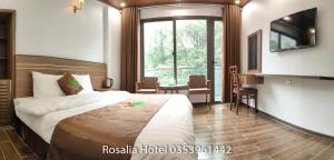 um quarto de hotel com uma cama e uma grande janela em Ros Hotel Tam Đảo em Tam Dao