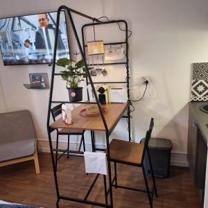 a shelf with a table and a chair in a room at Lyon Montchat Villeurbanne Studio refait à neuf climatisé et parking privé in Villeurbanne