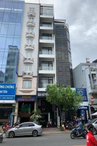 un edificio alto con un coche aparcado delante de él en Gia Huyen Hotel, en Ho Chi Minh