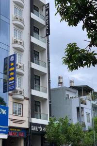 un edificio blanco alto con señales delante en Gia Huyen Hotel, en Ho Chi Minh