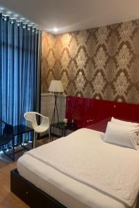 um quarto com uma cama grande e uma cadeira em Gia Huyen Hotel em Ho Chi Minh