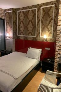 um quarto com uma cama e uma cadeira em Gia Huyen Hotel em Ho Chi Minh