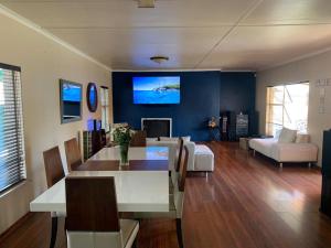 a living room with a dining table and a tv at 28 at Van Den Bos International Guesthouse in Edenvale