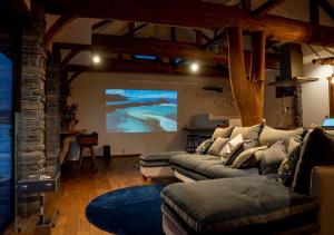 a living room with a couch and a large screen at 　白馬　コテージ　チェスナッツ in Hakuba