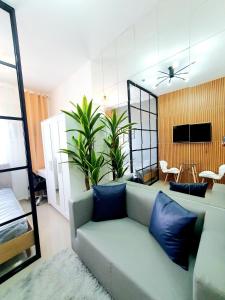 a living room with a couch and a dining room at Green 2 Residences Scandi-Industrial Hotel Type Interior in Dasmariñas