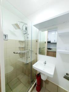 a white bathroom with a sink and a shower at Green 2 Residences Scandi-Industrial Hotel Type Interior in Dasmariñas