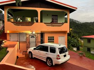 un coche blanco estacionado frente a una casa en Homely Environment Studio Apt en Gros Islet