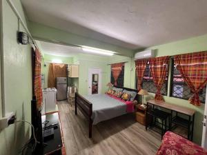 mała sypialnia z łóżkiem i kuchnią w obiekcie Homely Environment Studio Apt w mieście Gros Islet