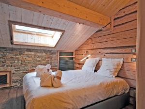 a bedroom with a bed in a room with wooden walls at Duplex confortable avec conciergerie à Méribel - FR-1-613-9 in Méribel