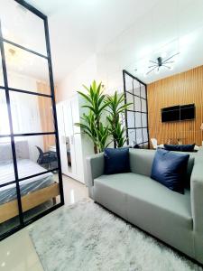 a living room with a couch and a bedroom at Green 2 Residences Scandi-Industrial Hotel Type Interior in Dasmariñas