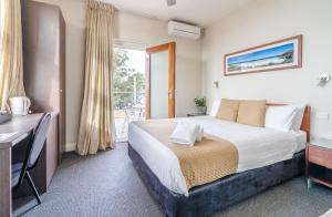 赫斯基森Huskisson Hotel的一间带床、书桌和窗户的酒店房间 更多23张照片