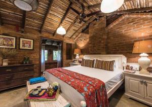 sypialnia z dużym łóżkiem i ceglaną ścianą w obiekcie Turia Villa Canacona Palolem w mieście Canacona
