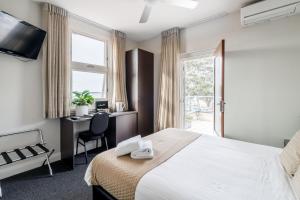 赫斯基森Huskisson Hotel的一间带床、书桌和窗户的酒店房间