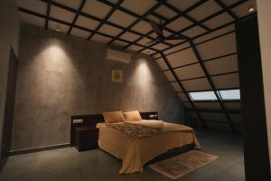 Nammal Resorts في Padinjarathara: غرفة نوم بسرير في غرفة ذات سقف