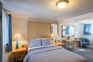 a hotel room with a bed and a desk and chairs at Gannett Peak Lodge in Pinedale