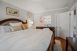 a bedroom with a large white bed and a table at Chevy Chase 4 BR 2 offices Comfortable Inviting in Washington, D.C.