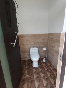 a bathroom with a toilet in a tiled floor at Maktub TlayaGlamping in Tlayacapan