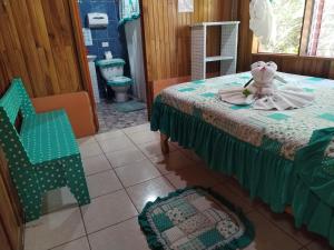 a room with two beds and a teddy bear on a table at Pensión y Cabinas Colibrí B&B Costa Rica in Monteverde Costa Rica