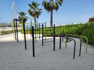 een speeltuin in het zand met palmbomen op de achtergrond bij The Star @ Address Beach Residence in Dubai