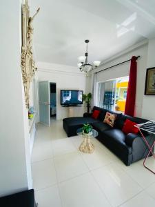 a living room with a black couch and a tv at Apartamentos Sweet Island in San Andrés