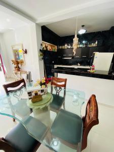 comedor con mesa de cristal y sillas en Apartamentos Sweet Island, en San Andrés