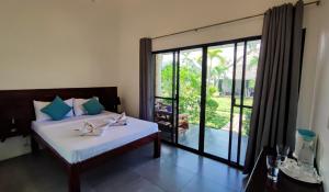 1 dormitorio con 1 cama y puerta corredera de cristal en Cabagnow Seaside Resort en Anda