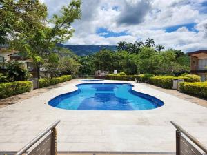 a large swimming pool in a yard with a fence at Precioso apartamento para disfrutar en familia in Villeta