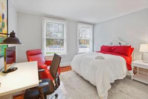 a bedroom with a bed and a desk and chairs at Chevy Chase 3 BR Chic Comfortable Spacious Luxury in Washington, D.C.