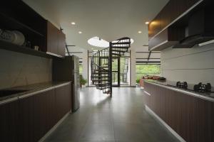 a kitchen with a staircase in the middle of a room at Nammal Resorts in Padinjarathara