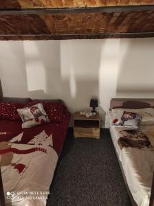 1 dormitorio con 2 camas y mesa con lámpara en Dawna Mleczarnia Apartament LOFT, en Nowa Ruda
