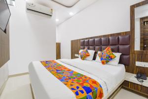 um quarto com uma cama grande e um cobertor colorido em FabExpress Sunrise em Ahmedabad