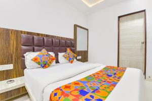 um quarto com uma cama grande e um cobertor colorido em FabExpress Sunrise em Ahmedabad