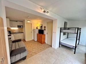 ein Wohnzimmer mit einem Etagenbett und eine Küche in der Unterkunft Appartement Marseillan-Plage, 2 pièces, 6 personnes - FR-1-387-165 in Marseillan