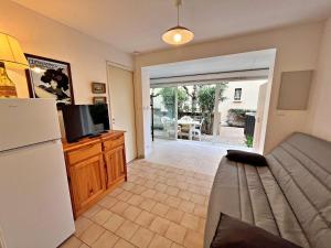 ein Wohnzimmer mit einem Kühlschrank und einem TV in der Unterkunft Appartement Marseillan-Plage, 2 pièces, 6 personnes - FR-1-387-165 in Marseillan