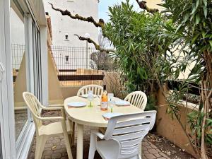 einen weißen Tisch und Stühle auf einer Terrasse mit Bäumen in der Unterkunft Appartement Marseillan-Plage, 2 pièces, 6 personnes - FR-1-387-165 in Marseillan