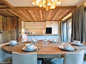 a dining room with a large wooden table and chairs at Appartement skis aux pieds avec concierge 5* à Méribel - FR-1-613-38 in Méribel