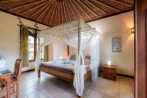 a bedroom with a canopy bed in a room at Villa Manuk in Singaraja