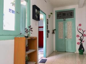 um corredor com uma porta verde num quarto em Garser em Yogyakarta