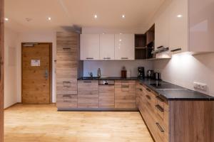 a kitchen with white cabinets and a black counter top at Luxapart Haus 2 in Ladis