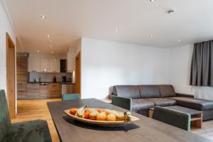 a living room with a table with a bowl of fruit on it at Luxapart Haus 2 in Ladis