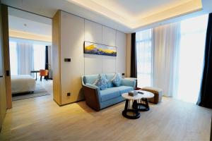 a living room with a blue couch and a table at Wyndham Handan Congtai in Handan +88 photos