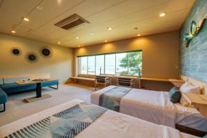 Habitación de hotel con 2 camas y escritorio en Fuji Lake Hotel, en Fujikawaguchiko